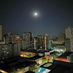 Illuminated buildings in city against sky at night