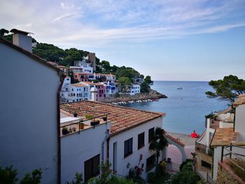 High angle view of townscape by sea against sky