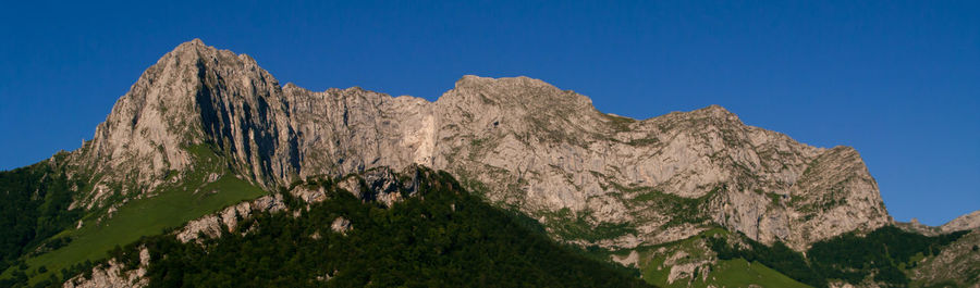 Low angle view of mountain against blue sky