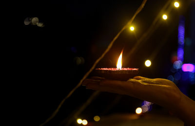 Person holding illuminated candles