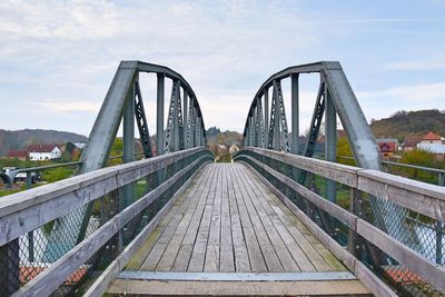 Footbridge against sky in city