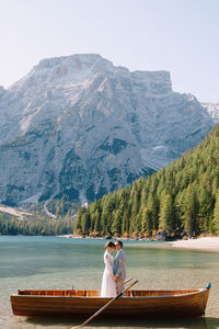 Woman on boat in lake against mountains