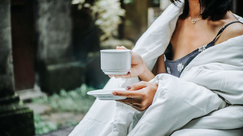 Midsection of woman holding coffee cup