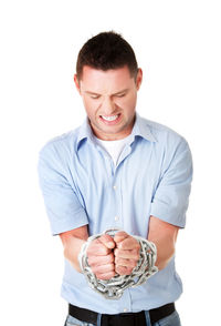 Frustrated man with chains tied on hands