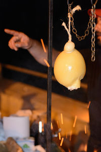 Close-of cheese hanging with man pointing in background