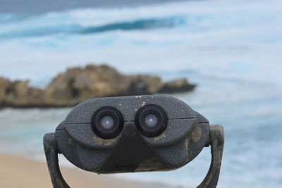 Close-up of coin-operated binoculars on beach