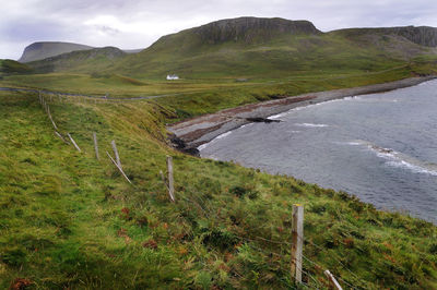 Scenic view of river by green mountains