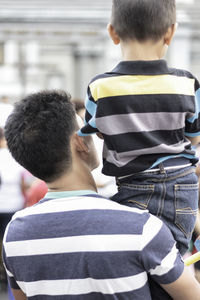 Rear view of man carrying son