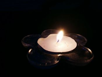 Close-up of burning candle in darkroom