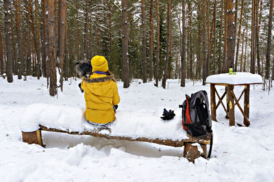 Rear view of people on snow covered field