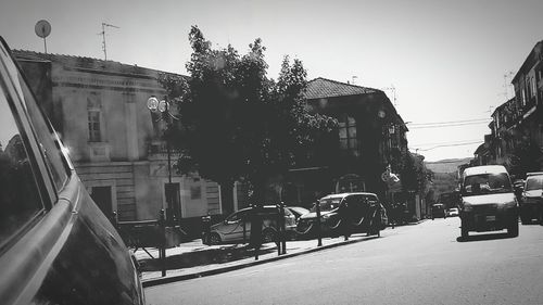 Cars on road against clear sky in city