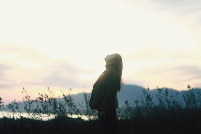 Woman standing on field against sky