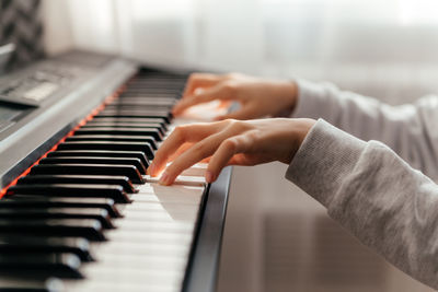 Close up hands of caucasian girl playing synthesizer.