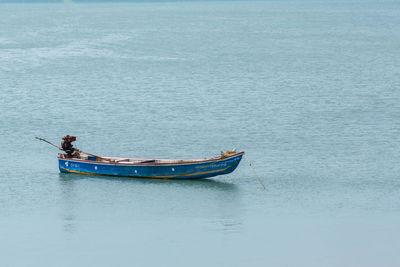 Man on boat moored in sea