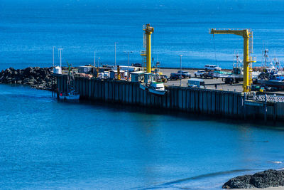 Boats at harbor against blue sky