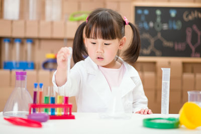 Young girl playing science experiment at home 