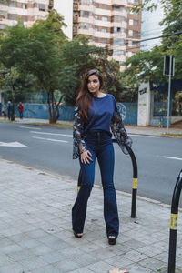 Full length portrait of woman on street in city