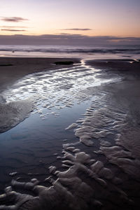 Scenic view of beach against sky during sunset