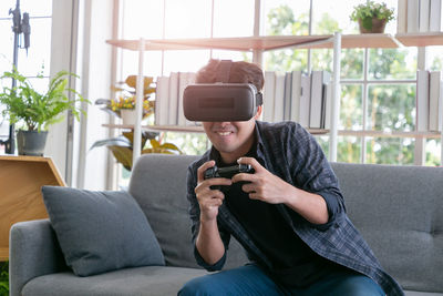 Man using mobile phone while sitting on sofa