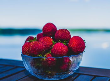 Close-up of strawberries on table against sea