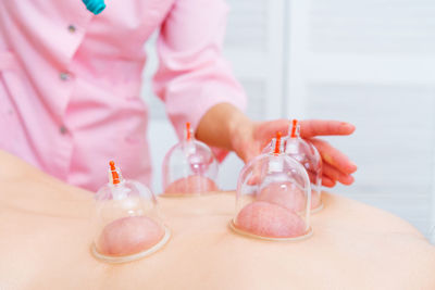 Relaxed young woman receiving canning on her back at spa. vacuum massage. woman