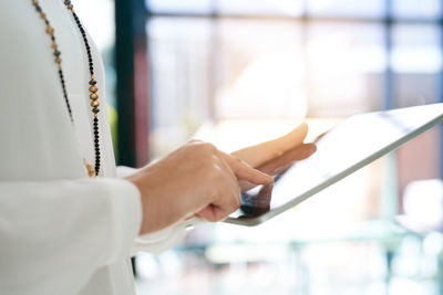 Midsection of man using digital tablet