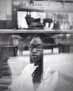 Portrait of young woman seen through glass