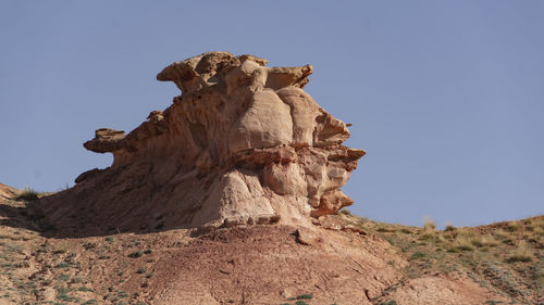 Low angle view of rock formation against clear sky