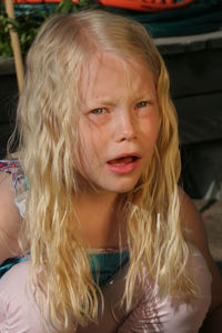 Close-up portrait of girl crying while crouching outdoors
