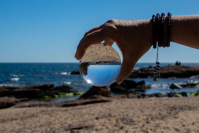 Man holding umbrella on beach
