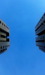 Low angle view of skyscrapers against blue sky