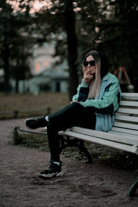 Woman sitting on bench in park