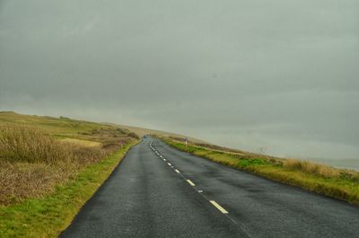 Empty road along countryside landscape