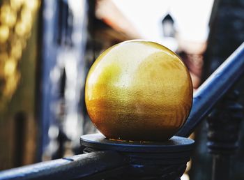 Close-up of gold metallic sphere on railing