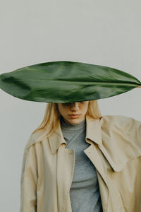 A portrait of a young woman holding a plant leaf