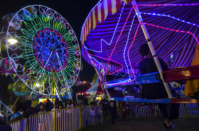 Low angle view of illuminated ferris wheel against sky at night