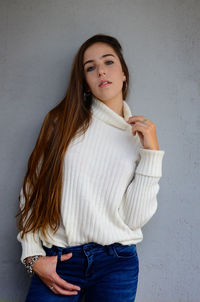 Portrait of beautiful woman standing against wall