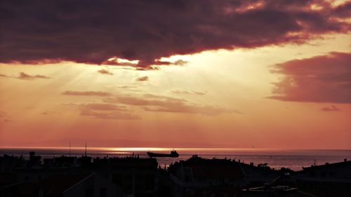 Scenic view of sea against cloudy sky during sunset