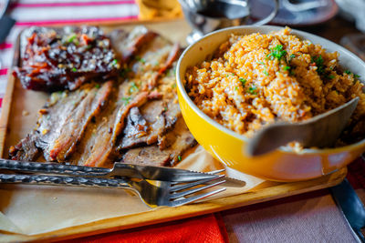 Grilled ribs and prok belly striped served with sauce and java rice.