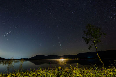 Scenic view of lake against star field sky at night