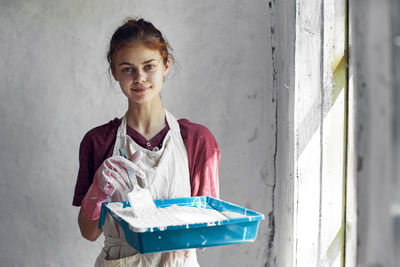 Young woman standing against wall