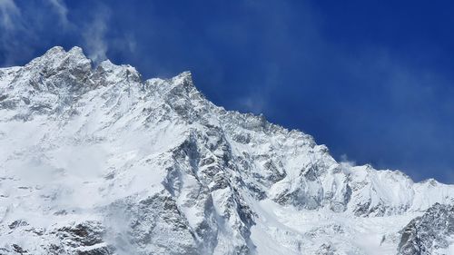 Low angle view of snowcapped mountain against sky