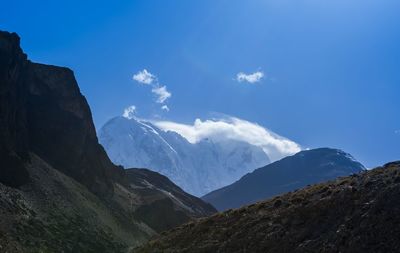 Scenic view of mountains against blue sky