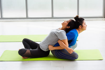 Full length of women exercising at gym