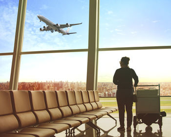 Rear view of woman standing at airport terminal