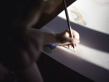 Shadow of woman holding hands on wall