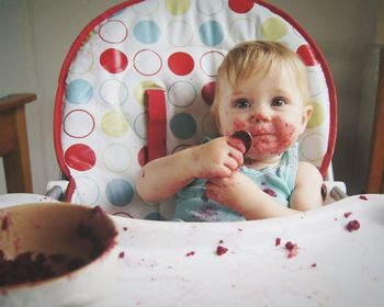 Portrait of woman eating food in kitchen