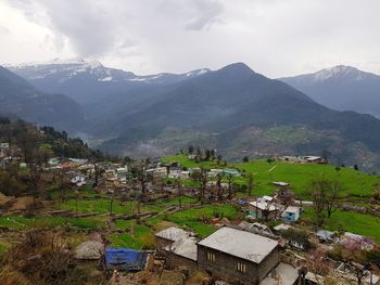 Scenic view of houses and mountains against sky