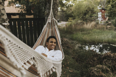 Smiling man relaxing on hammock