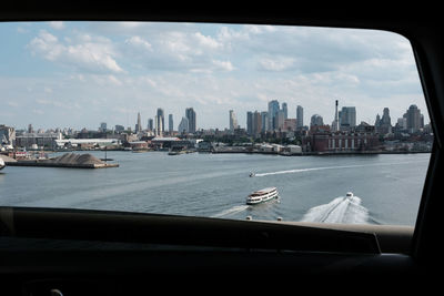 Boats in river with cityscape in background